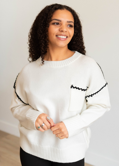 Ivory knit sweater with front pocket with black trim