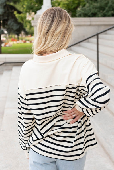 Back view of the black stirpe pullover top with cream shoulder fabric