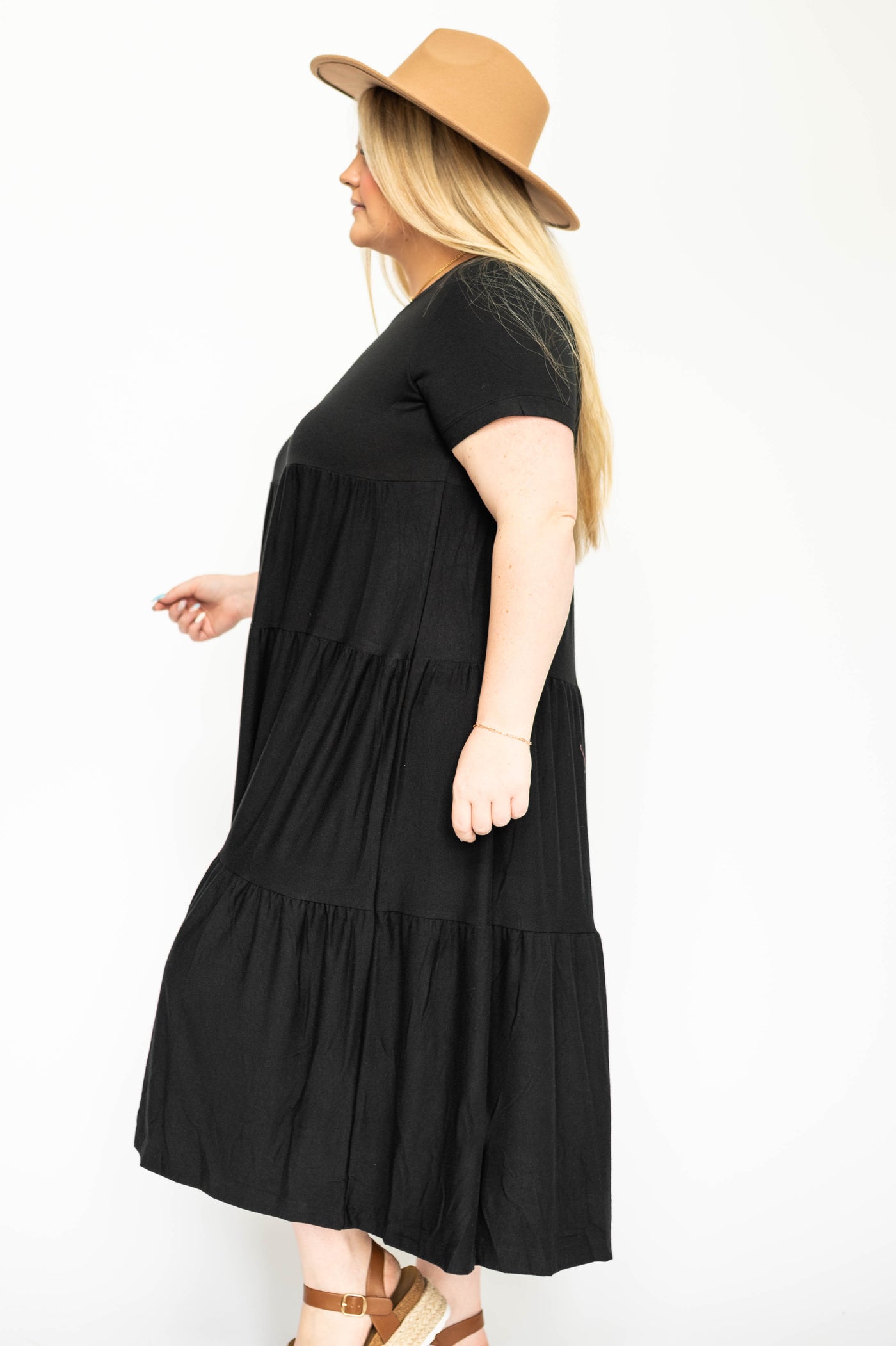 Side view of a plus size black tiered dress