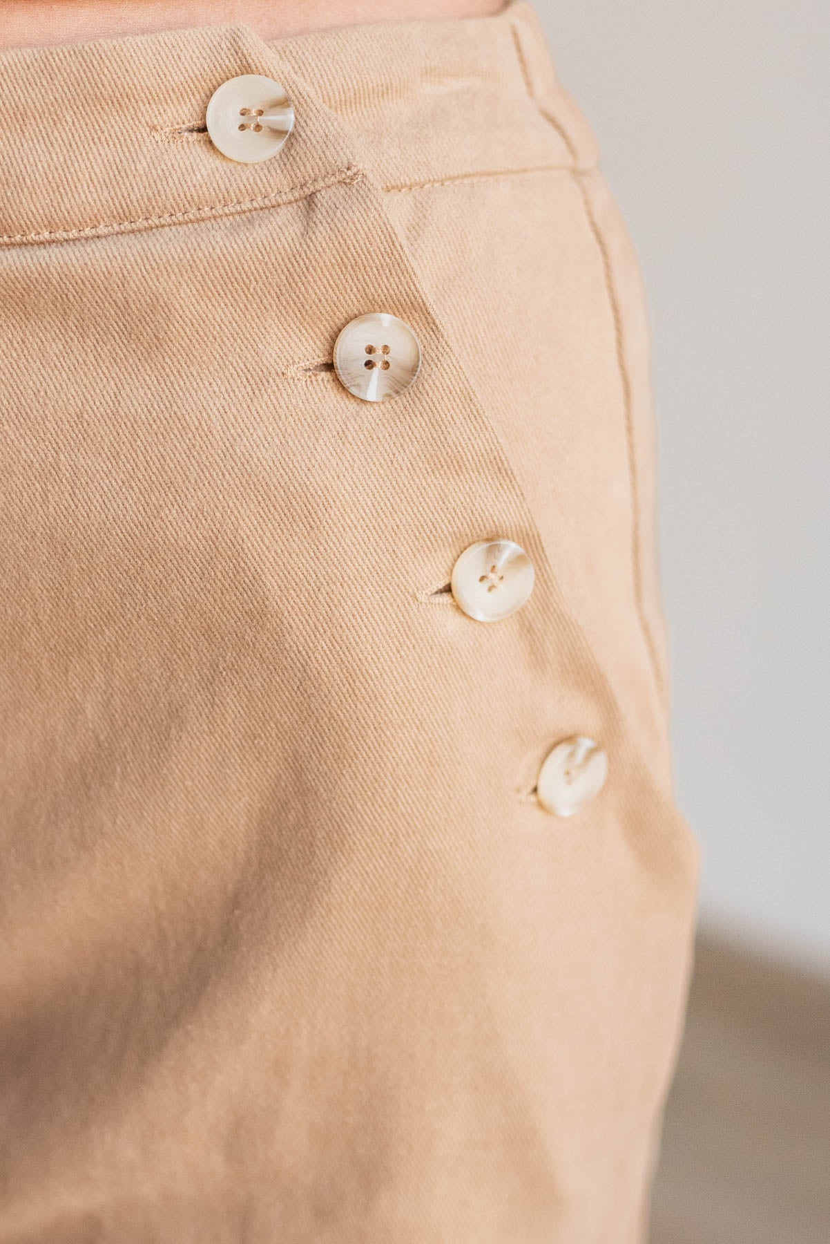 Close up at the buttons on the tan wide leg pants