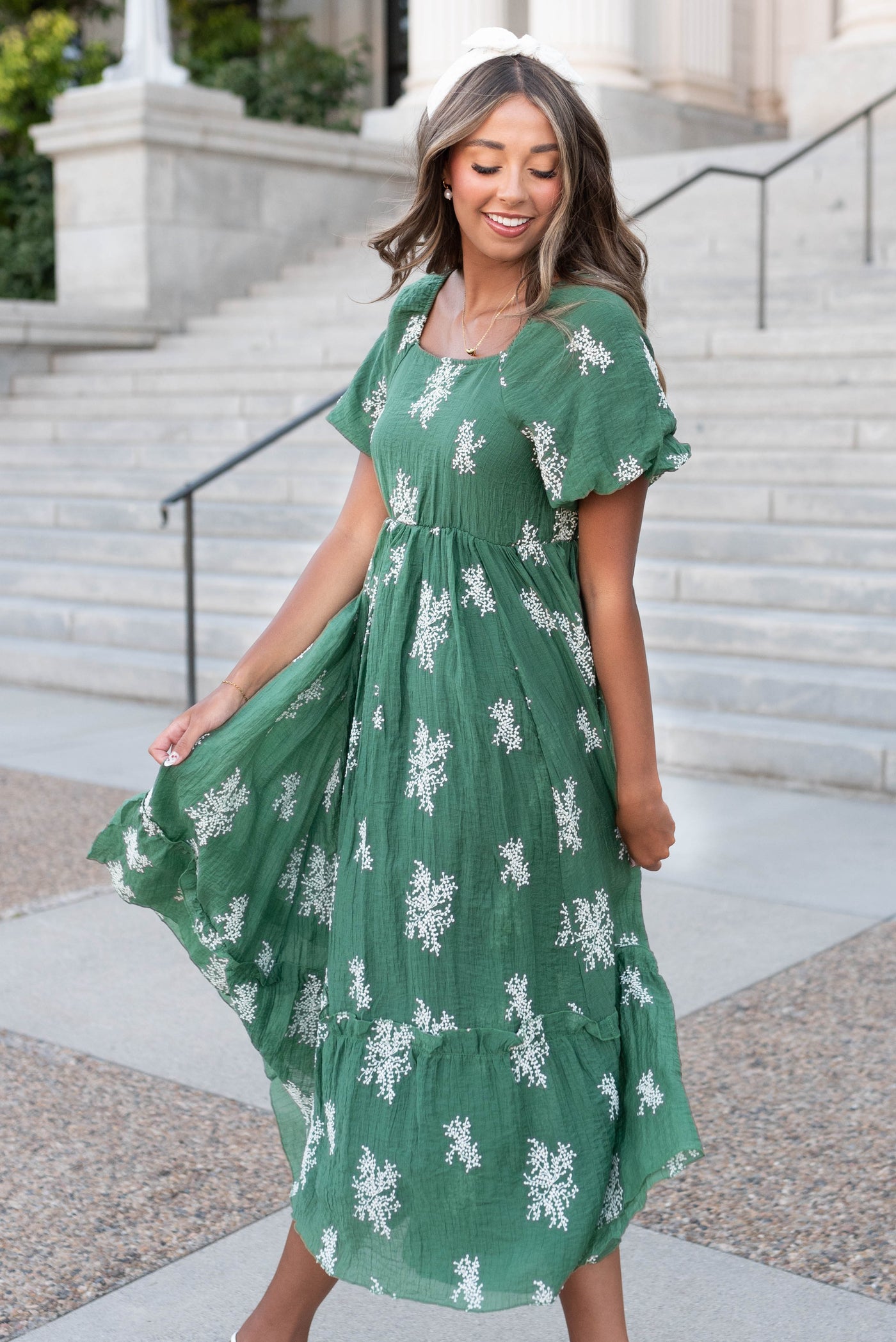 Side view of the emeral green embroidered dress with white flowers