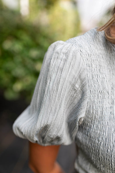 Close up of the sleeve on the dusty blue smocked dress