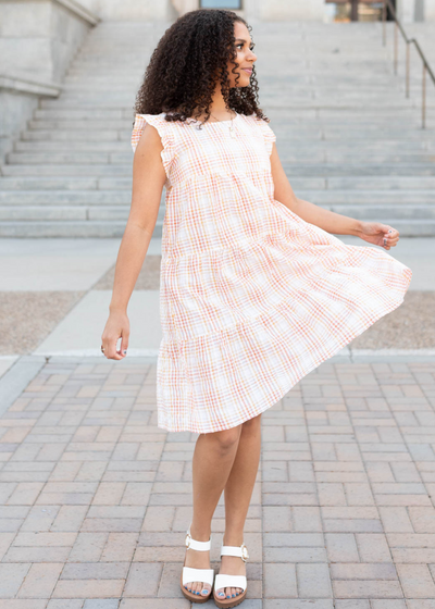 Orange plaid mini dress that is sleeveless with a ruffle sleeve