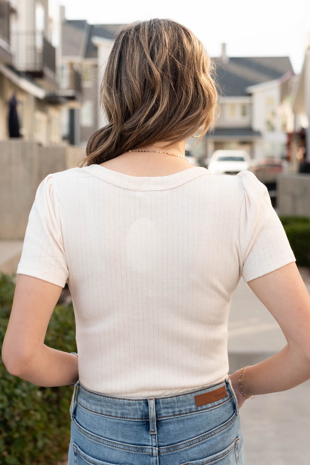 Back view of the cream bow bodysuit