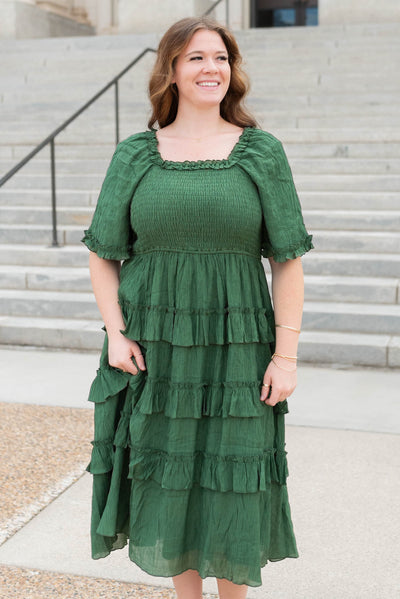 Front view of the green textured ruffle tiered dress with ruffle around the neck