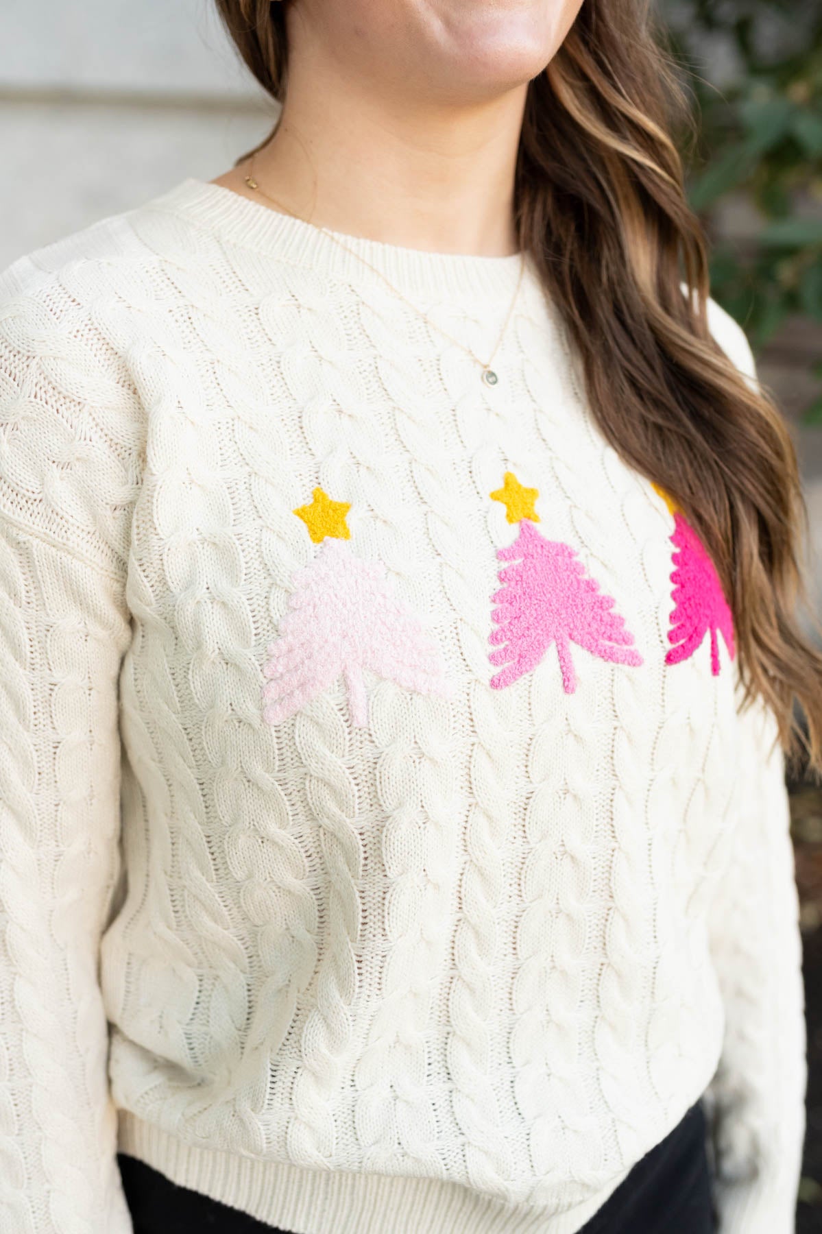 Close up of the pink trees on the cream embroidered tree sweater