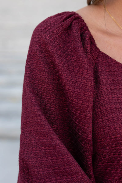 Close up of the fabric on the burgundy textured dress