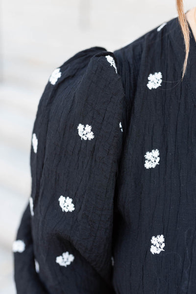 Close up of the flowers on the black embroiered button dress