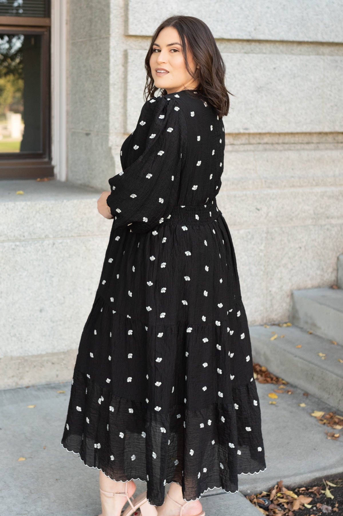 Side view of the black embroidered button dress in plus size