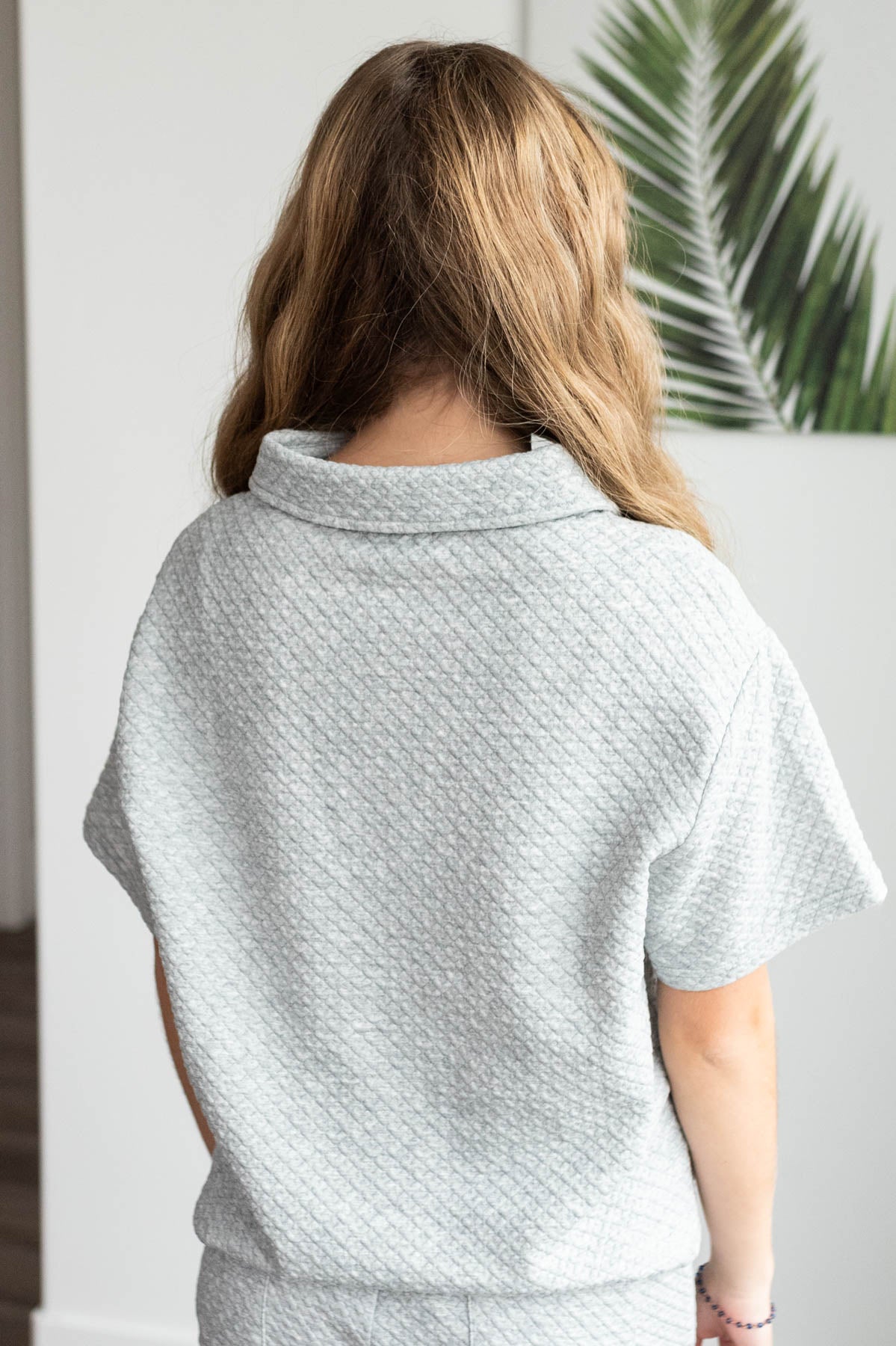 Back view of the heather grey collared knit top