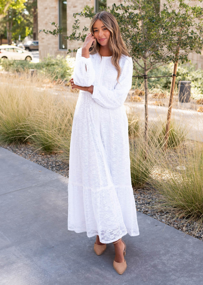 White floral lace dress with button closures on the cuffs