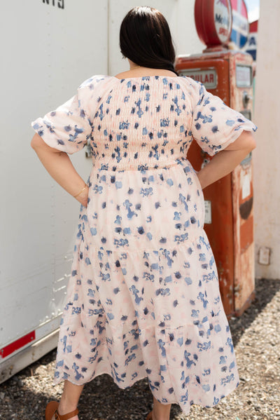 Back view of a plus size blue floral smocked dress