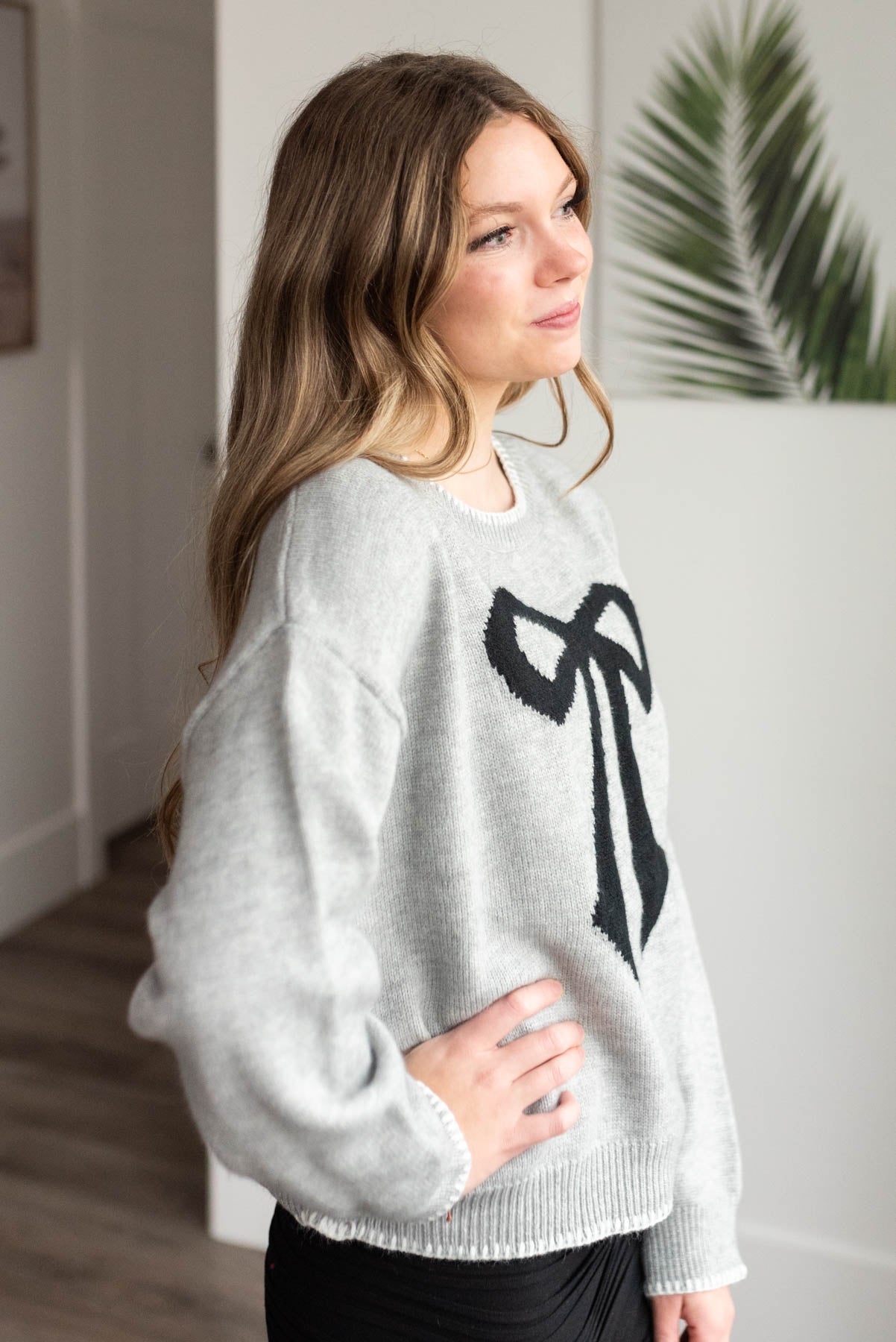 Side view of the heather grey bow sweater