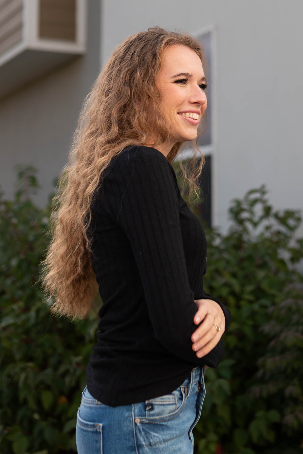 Side view of the black ribbed long sleeve top