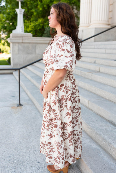 Side view of the plus size mocha floral tiered dress with puff sleeves