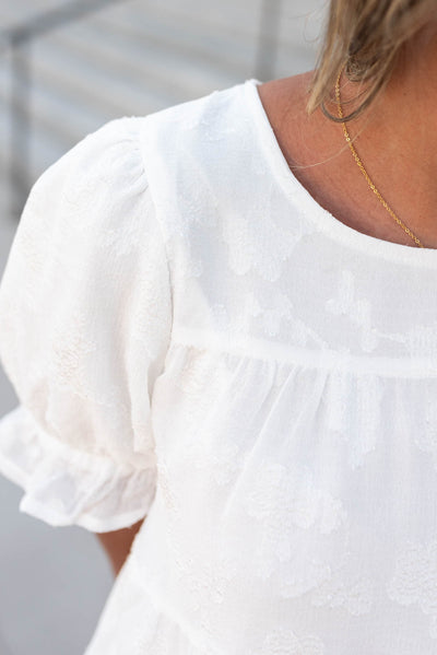 Close up of the fabric on the white flroal ruffle top