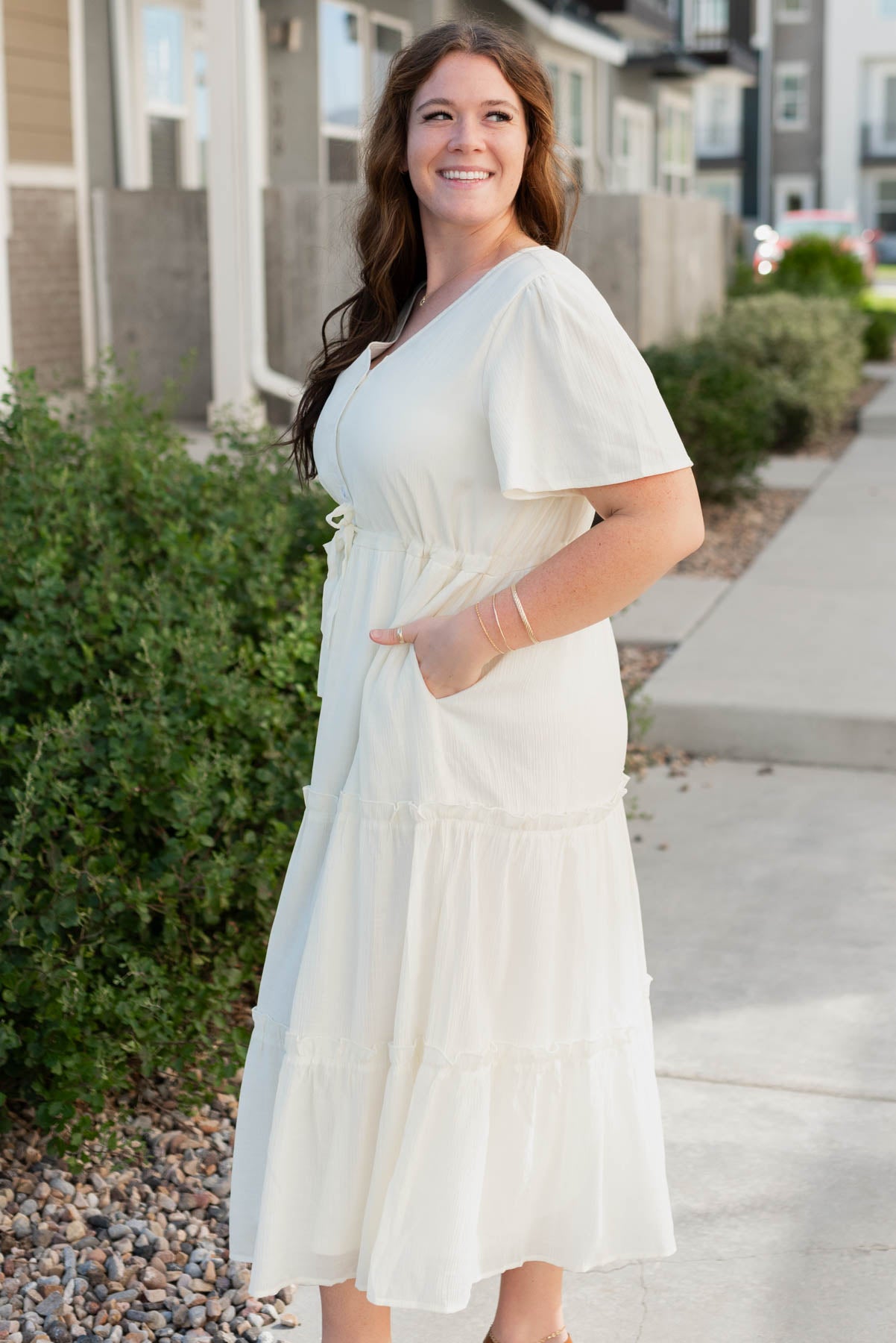 Side view of the cream buttondown dress with pockets