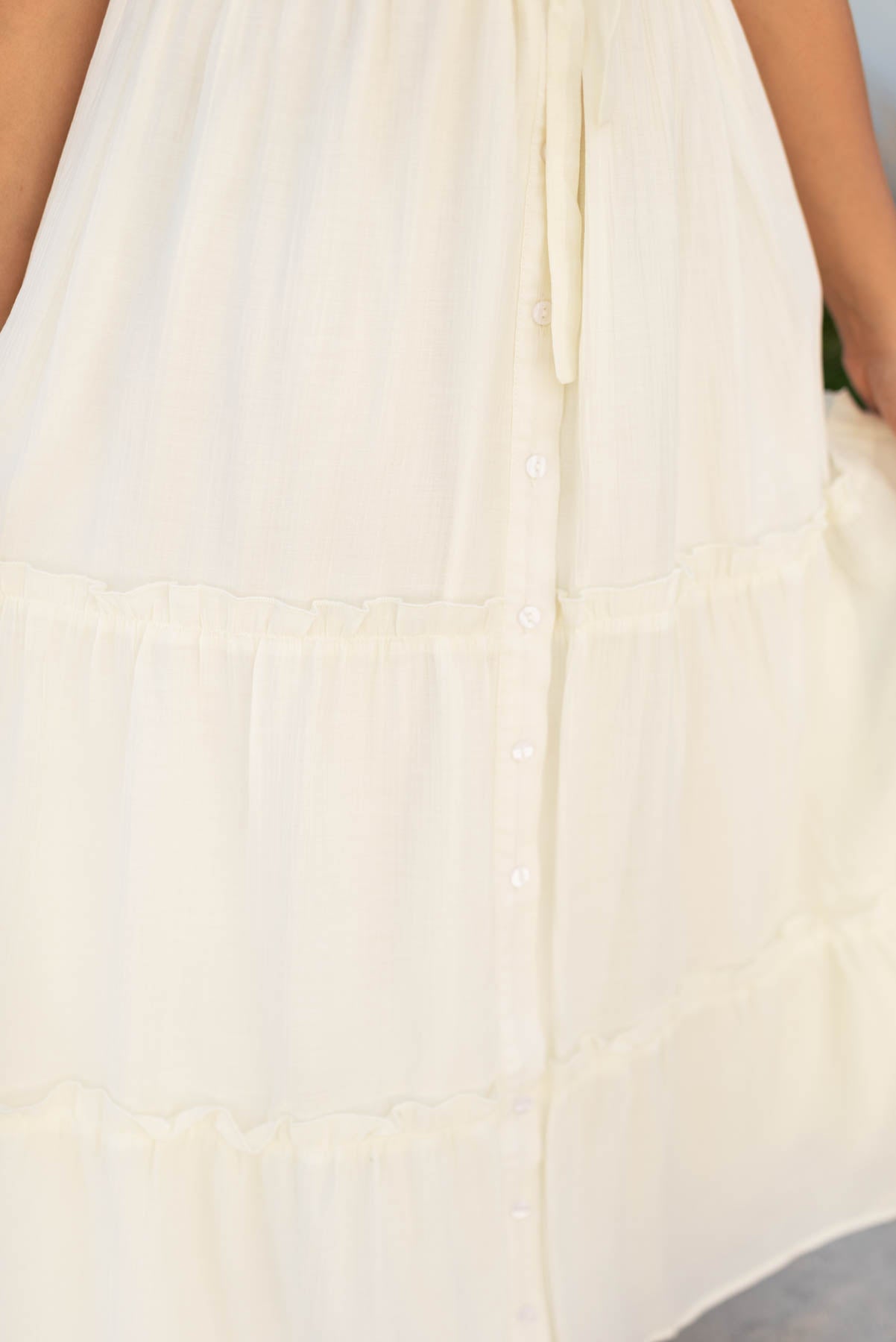 Close up of the front buttons on the cream button down dress