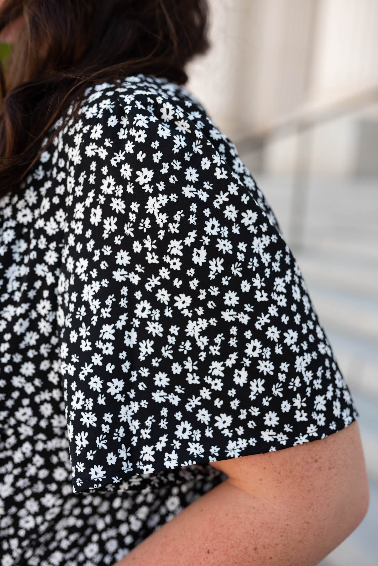 Close up of the fabric and sleeve on the plus size black ditsy floral dress