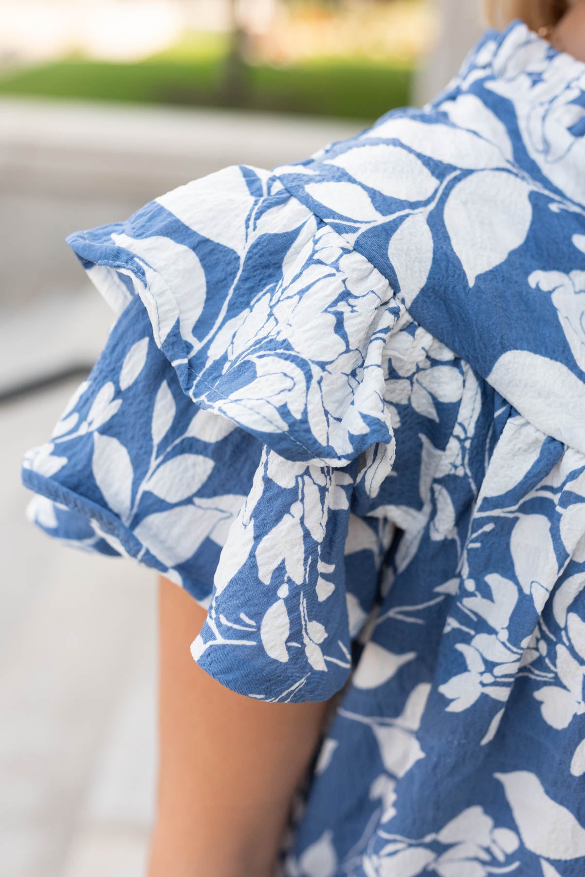 Close up of the blue floral ruffle top sleeve and fabric