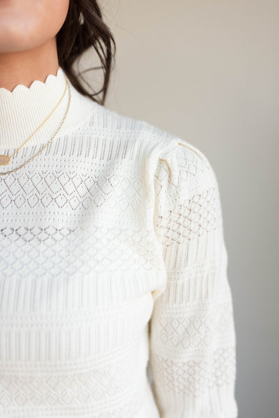 Close up of the knit stitch on the ivory pattern sweater.