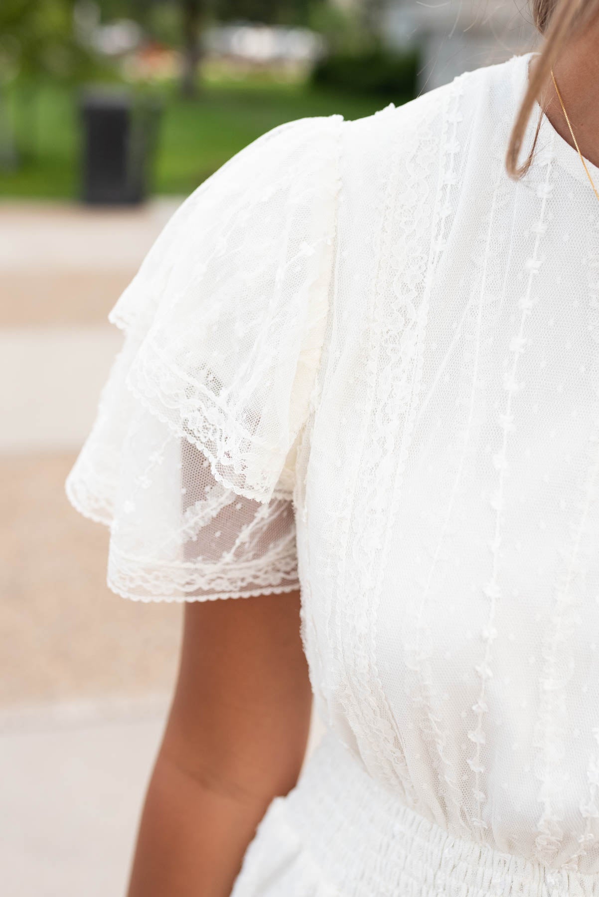 Close up of the lace and sleeve on the cream lace dress