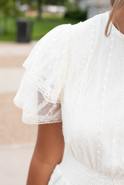 Close up of the lace and sleeve on the cream lace dress