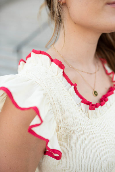 Close up of the the neckline and sleeves on the cream red midi dress