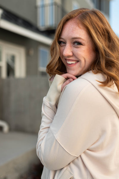 Side view of a long sleeve oatmeal hoodie with front pocket