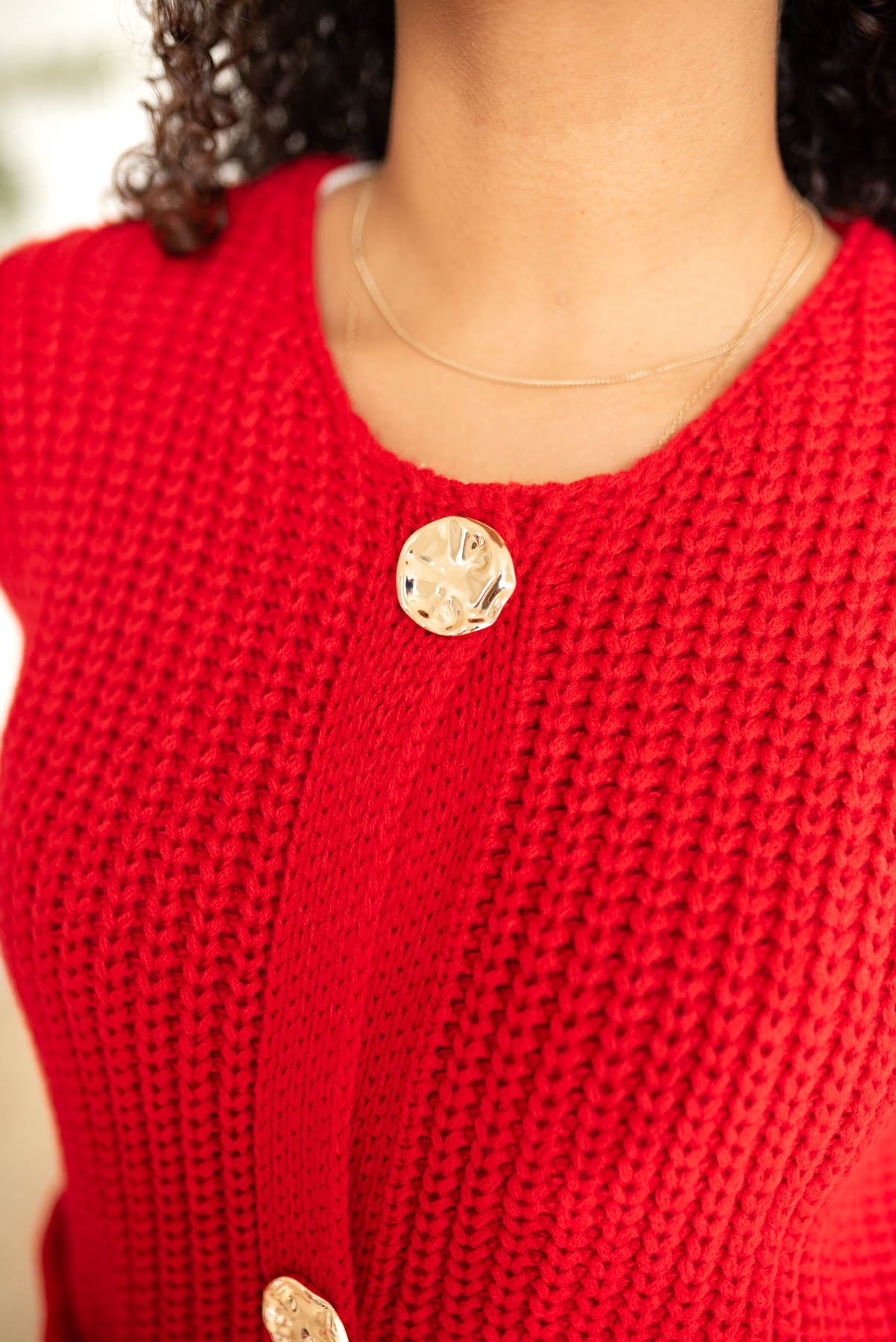 Close up of the buttons on the red knit sweater vest