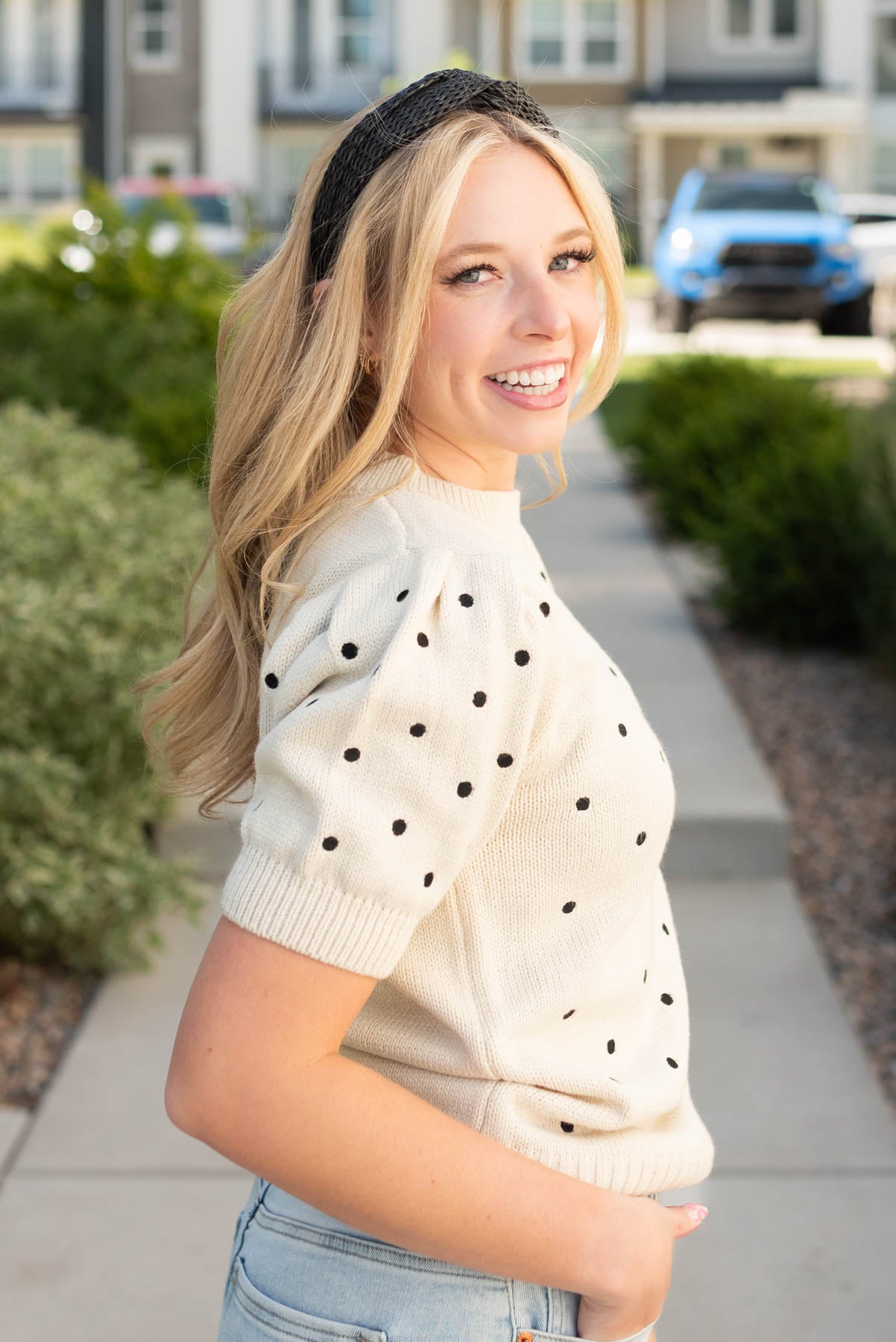 Side view of the cream black dot sweater