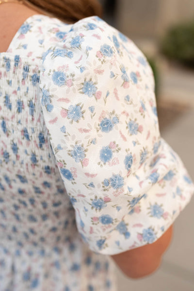 Close up of the sleeve and fabric on the white blue floral dress