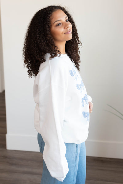 Side view of the white bows graphic sweatshirt with long sleeves