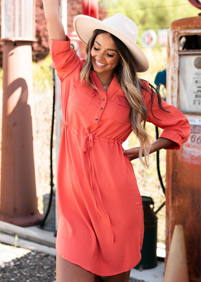 Front view of a terracotta dress with collar and buttons that ties at the waist 