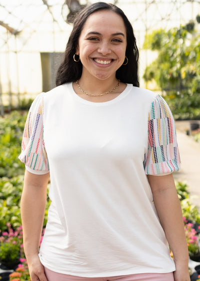 Front view of a white top with short colorful sleeves